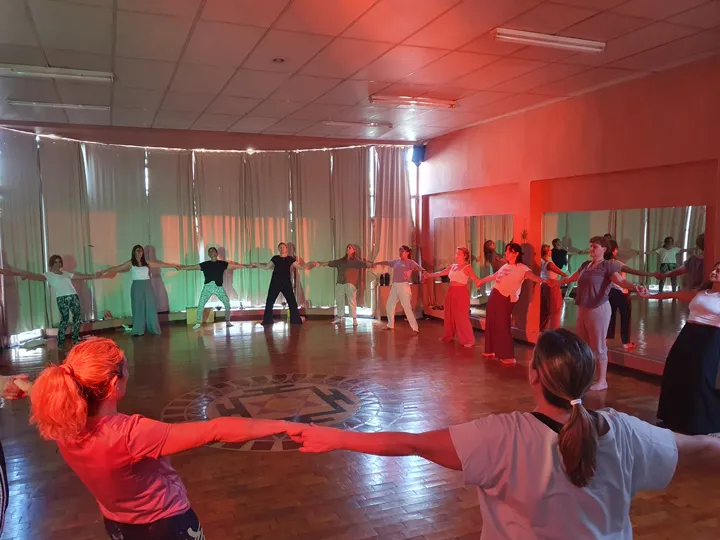 Ronda de mujeres paradas y tomadas de las manos. Taller anual Astrología Viva – Meditación en Movimiento. Para conectar el cielo con el cuerpo.