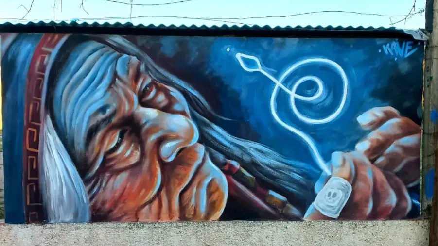 un mural de una chamana, junto a ella, en blanco, un codigo de luz que dibuja un espiral y asciende